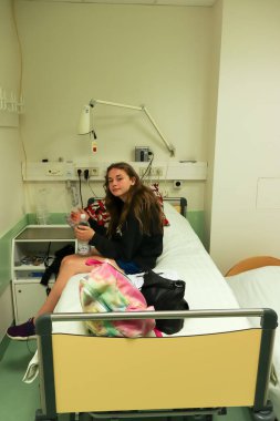 Genç bir kız, odasında bir yatağın üzerinde hastaneye yatırıldı..
