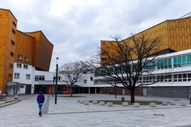 Almanya 'daki Berlin Filarmoni Konser Salonu' nun önünde yürüyen insanlar.