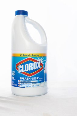 Beyaz arka planda beyaz kumaş üzerine çamaşır suyu kabı.