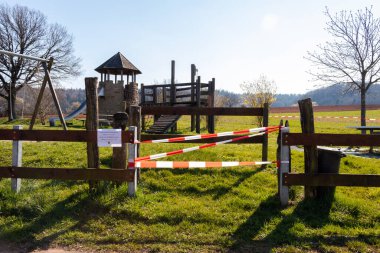 Oyun parkı, Corona virüsü nedeniyle girilmesine izin verilmediğini söyleyen bir tabelayla kapatıldı (COVID19). Güneşli bir bahar gününde Potzbach, Almanya 'da park.