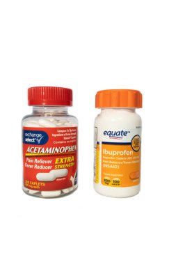 Beyaz arka planda yan yana bir şişe asetaminofen ve ibuprofen..