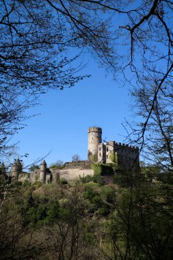 Güneşli bir bahar gününde, Almanya 'nın Roes yakınlarındaki ağaçlarla çevrili bir tepede Burg Pyrmont..
