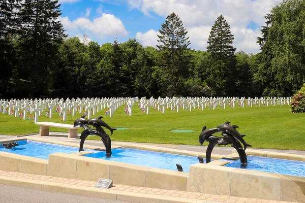 Lüksemburg Amerikan Mezarlığı 'ndaki yunus çeşmesi ve arka planda mezarlarla birlikte anıt..