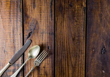 Kırsal ahşap bir masa üzerine çatal bıçak seti. Çatal, kaşık ve bıçak. Yemek konsepti. Boşluğu Kopyala