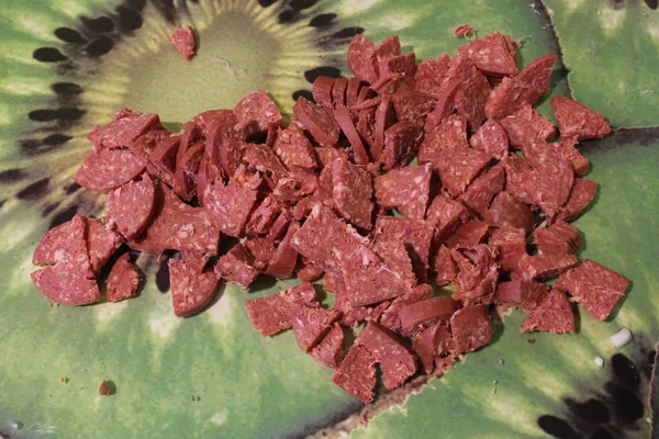Turkish raw sausage sucuk cut to small pieces on a glass cutting board as ingredient for soup — Stock Photo, Image