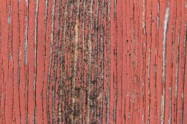 Kırmızıya boyanmış eski ahşap dokusu soyuluyor.