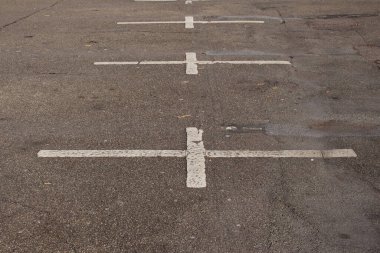 Eski, kirli ve solgun beyaz işaretler boş bir otoparkta