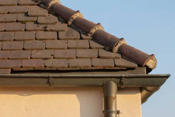 Side view of a rain gutter and a roof tiles