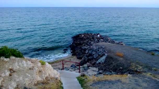 Vista sobre un mar con paso conduce a la playa con rocas y arena — Vídeo de stock