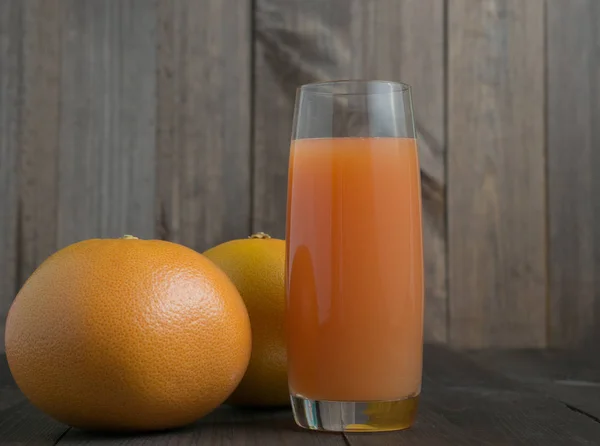 Two grapefruits with glass of juice — Stock Photo, Image