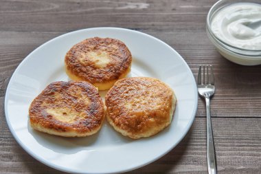 karanlık masada beyaz plaka üzerinde üç krep