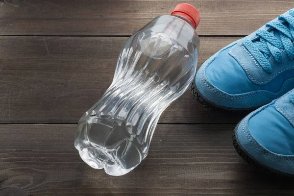 Пляшка води і пара кросівок — стокове фото