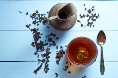 bardak çay, sürahi, çay yaprakları ve çay kaşığı ile masa üzerinde top havadan görünümü