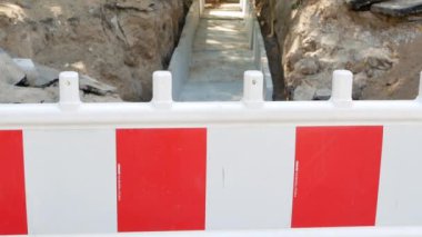 Su boruları ya da ısı kaybını önlemek için beton kaplamalı gaz boruları için toprak çukurundaki çit uyarı çiti. 4k Uhd video kaydı