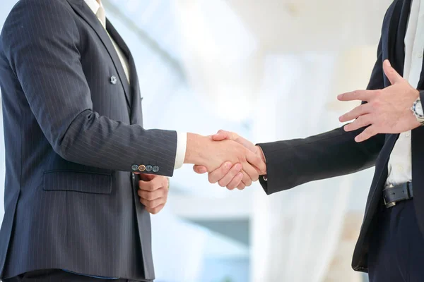 Confirmation of the transaction handshake. Two Confident businessman shake hands with each other in the business office