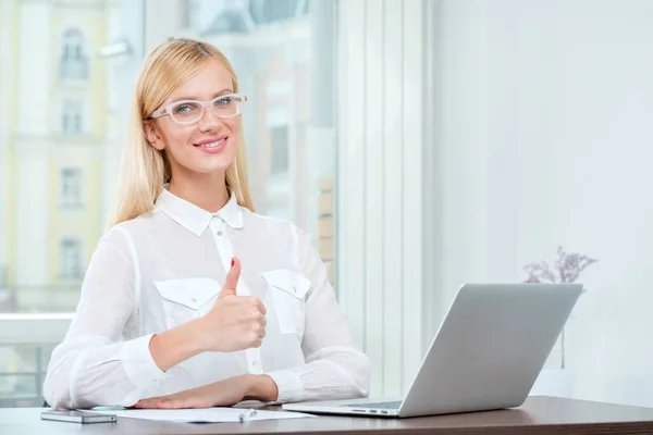 Best employee. Successful business woman in glasses holding a pen in office