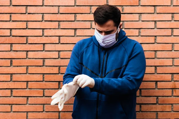 Adam sokağa tuğla kaplı eldivenler koyuyor.