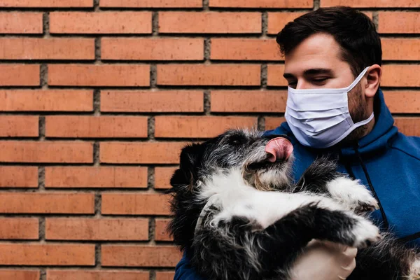 Adam köpeklerini kollarına alıyor.