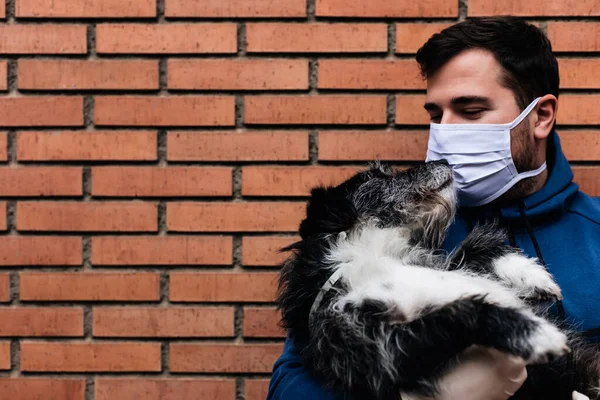 Adam köpeklerini kollarına alıyor.