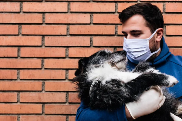 Adam köpeklerini kollarına alıyor.