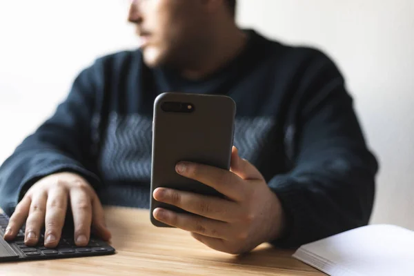 Evde orta yaşlı bir adam akıllı telefon ve tabletle bağlanmış..