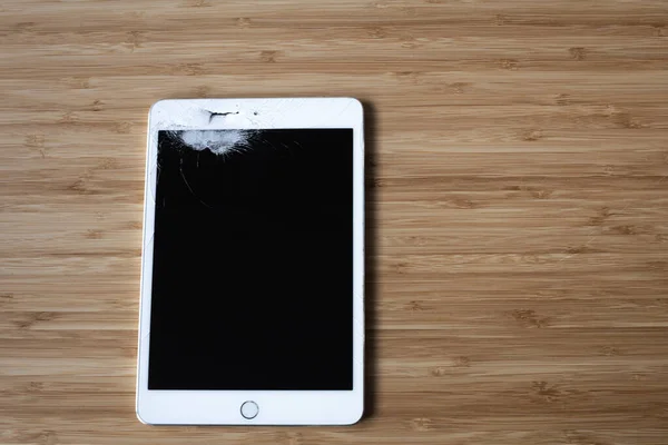 Ahşap arka planda kırık beyaz tablet