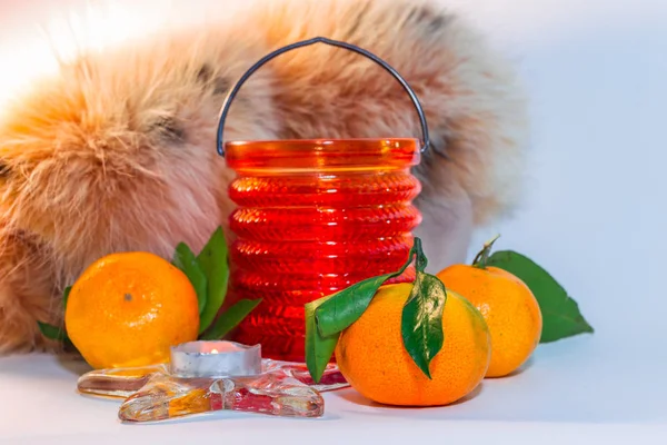 Stilleben med mandariner, fjäder sjal och ett ljus i en cand — Stockfoto