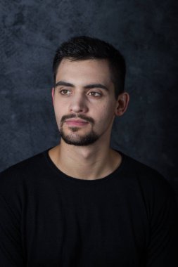 karanlık bir arka plan üzerinde genç bir adam portresi. Bir esmer bir whit