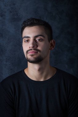 karanlık bir arka plan üzerinde genç bir adam portresi. Bir esmer bir whit