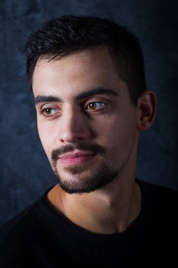 karanlık bir arka plan üzerinde genç bir adam portresi. Bir esmer bir whit