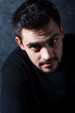 karanlık bir arka plan üzerinde genç bir adam portresi. Bir esmer bir whit