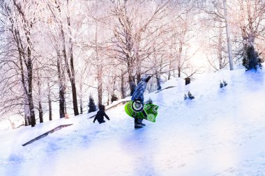 Kış resmi, güneşli bir gün, bir kar slayt, insan ve çocuk