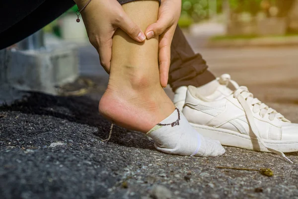 Jovem mulher tocando seu tornozelo doloroso, sofrendo de inju tornozelo — Fotografia de Stock