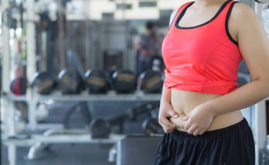 Aşırı şişman göbek tutan yakın bir kadın. Kadın kilolu abd