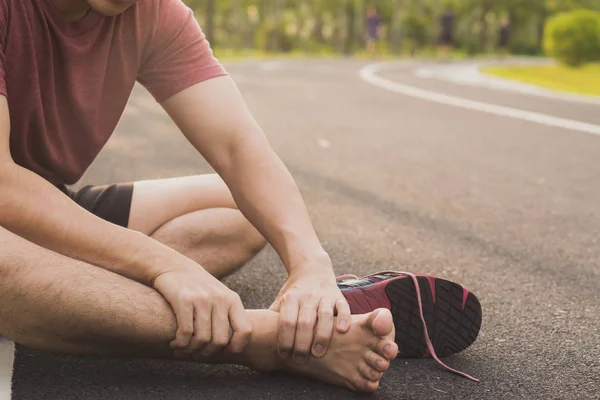 Ankle sprained. Young man suffering from an ankle injury while r