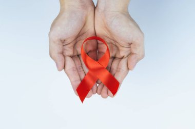 AIDS farkındalığı, kırmızı yardım şeridi tutan erkek elleri. 
