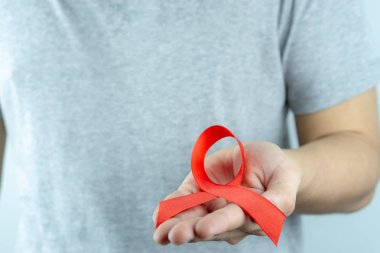AIDS farkındalığı, kırmızı yardım şeridi tutan erkek elleri. Vay canına.