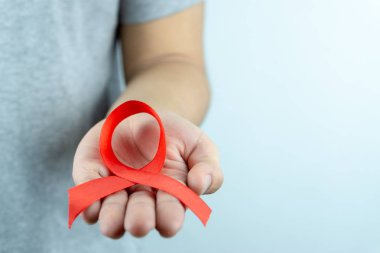 AIDS farkındalığı, kırmızı yardım şeridi tutan erkek elleri. Vay canına.