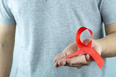 AIDS farkındalığı, kırmızı yardım şeridi tutan erkek elleri. Vay canına.