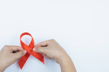AIDS farkındalığı, kırmızı yardım şeridi tutan erkek elleri. 