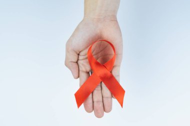 AIDS farkındalığı, kırmızı yardım şeridi tutan erkek elleri. 