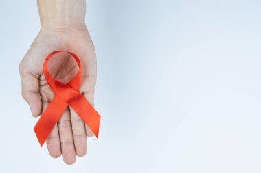 AIDS farkındalığı, kırmızı yardım şeridi tutan erkek elleri. 