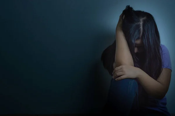 Sad woman hug her knee and cry sitting alone in a dark room. Dep — Stock Photo, Image