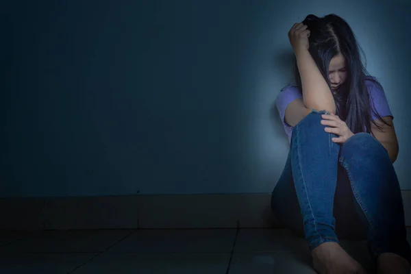 Sad woman hug her knee and cry sitting alone in a dark room. Dep — Stock Photo, Image