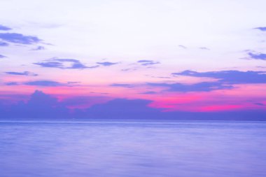 Okyanusun üzerinde dramatik bulutlarla gün batımı.