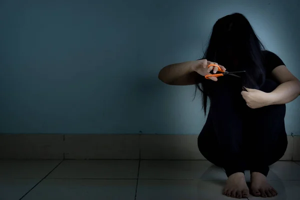 Wanita sedih menangis duduk sendirian dan memotong rambutnya dengan gunting i — Stok Foto