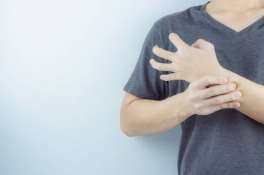 Yakından bakan adam beyaz arka planda bilek ağrısını tutuyor. Sağlık arabası