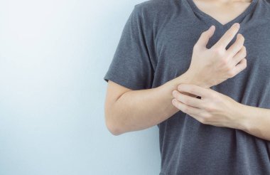 Yakından bakan adam beyaz arka planda bilek ağrısını tutuyor. Sağlık arabası