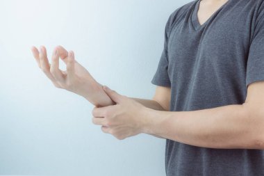 Yakından bakan adam beyaz arka planda bilek ağrısını tutuyor. Sağlık arabası