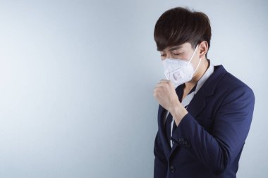 İş adamı Coronavirus ve Öğleden Sonra 2.5 'ten dolayı grip öksürüyor. Coronavirus ve Hava Kirliliği Öğleden Sonra 2.5 kavramı.